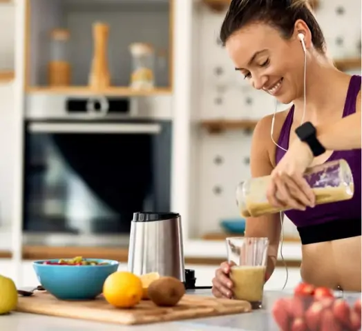 Woman making protein shake after exercise.