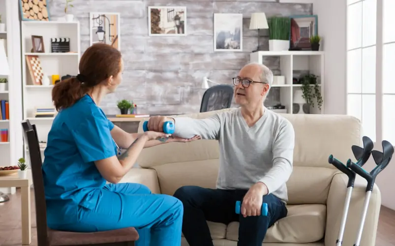 Female doctor, caregiver or personal trainer helping senior patient in weightlifting for healthy body